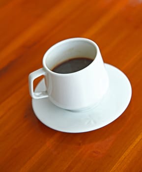 White Cup of Hot Espresso coffee on Wooden Table