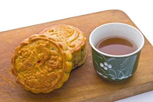Chinese Moon Cake, traditional food for the Chinese mid Autumn festival, with tea on wooden board.