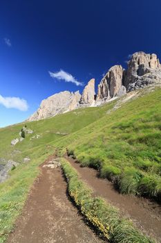 hike beneath Sassolungo Mount on summer, Trentino, Italy