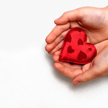 two hands holding a red heart