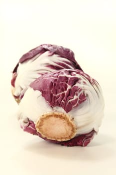 two heads of fresh raw radicchio on a light background