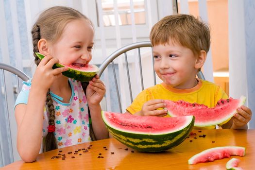 boy and girl eat ripe watermelon