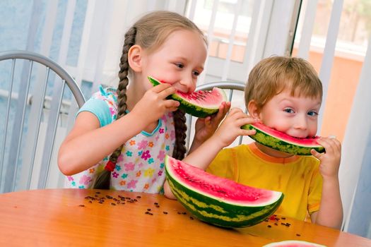 boy and girl eat ripe watermelon