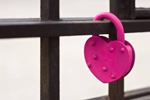 Pink heart love lock on the bridge