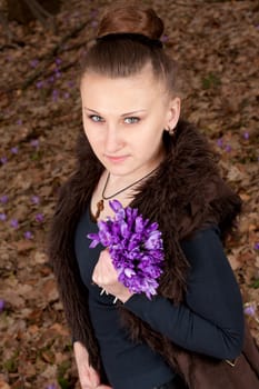 beautiful girl with snowdrops in a forest