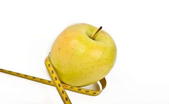 yellow apple with measuring tape on white background