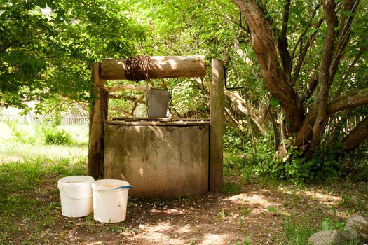 an old water well in the shade of trees