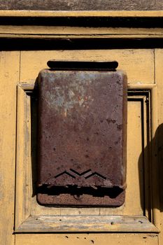 old rusty metal letter box to a wooden door