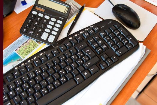 office desk with keyboard, calculator, mouse and pen