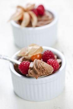 Two chocolate mousse desserts with a spoon