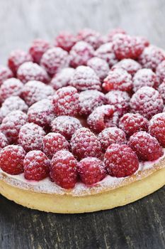 Fresh dessert fruit tart covered in raspberries