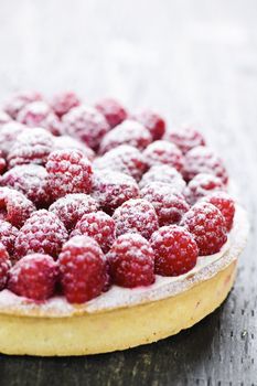 Fresh dessert fruit tart covered in raspberries