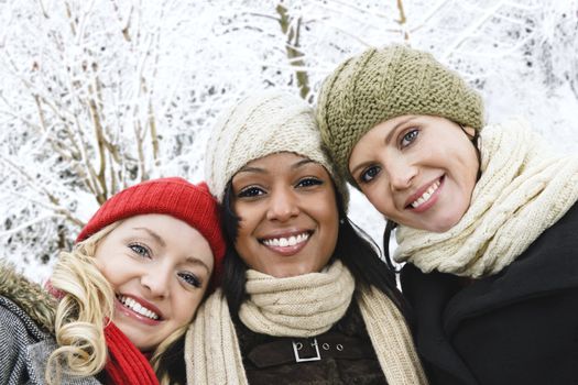 Group of three diverse young girl friends outdoors in winter