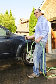 Man washing his car on the driveway
