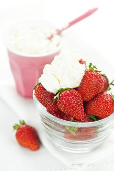 Bowl of fresh organic red strawberries with whipped cream