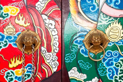 Lion knocker on surface of chinese door (Generality in Thailand,any kind of art decorated in Buddhist church etc. created with money donated by people, no restrict in copy or use)