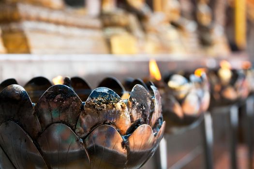 Coconut oil lamps in a buddhist temple shallow focus