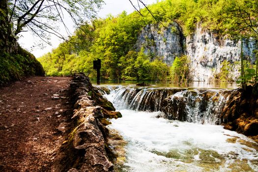 Beaten track near a forest lake and waterfall in Plitvice Lakes National Park, Croatia