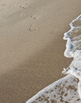 Steps on the beach entering in the sea.