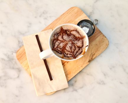 Hot chocolate with syrup on chopping board