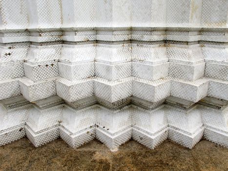 Old white serration wall on granite floor
