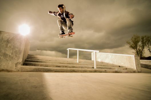 Skateboarder jumping over the stairs on a big ollie.