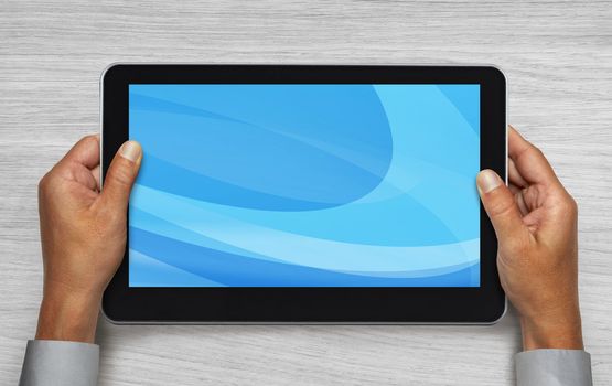 hands of businessman holding touchpad pc under table