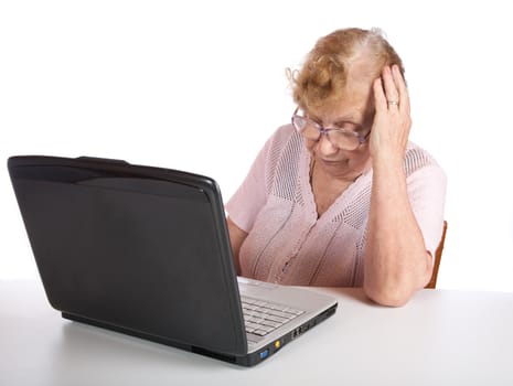 The old woman in glasses looks at the screen notebook on a white background