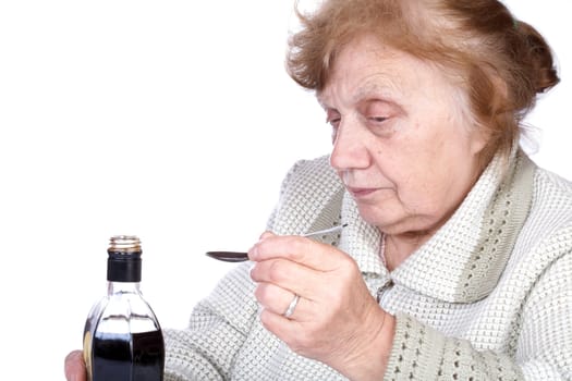 The old woman pours a liquid in the spoon