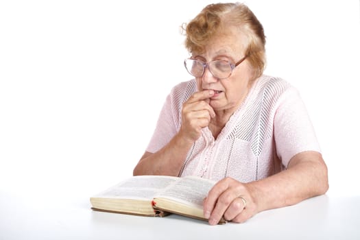 old woman in glasses reads the book on a white background