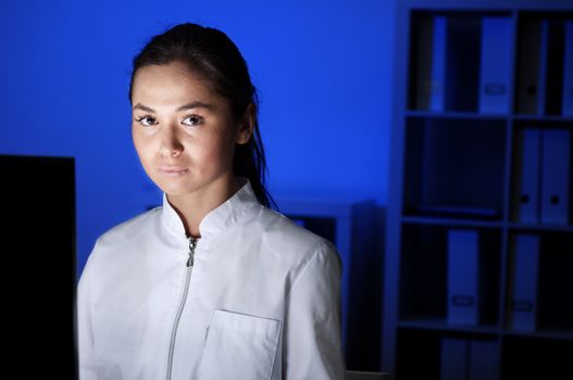 beautiful young woman doctor working at night in the office