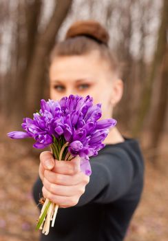 beautiful girl with snowdrops in a forest