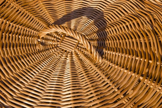 Background of hand-woven basket from reed lid with handle. Rural crafts.