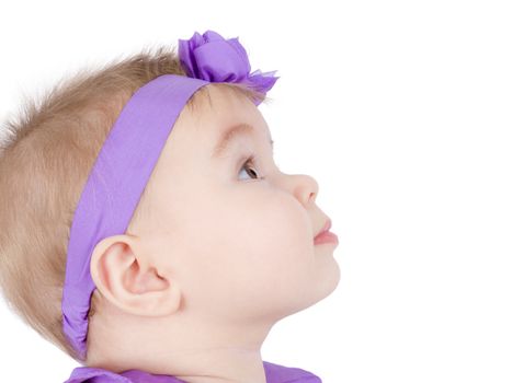 Pretty little girl is in her headband observing something, perhaps her parents.