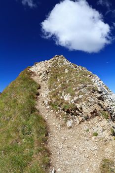 white clouds over mountain summit in Italian Dolomites. Photo taken with polarized filter