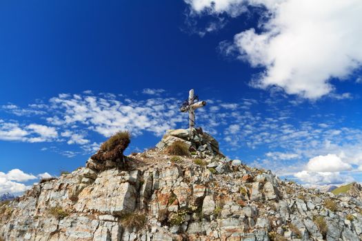 small cross with barbed wire on Doloomites Peak