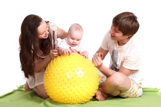 Portrait of a young family on a white background. The father, mum and the son. A horizontal. Parents play with the son a yellow ball