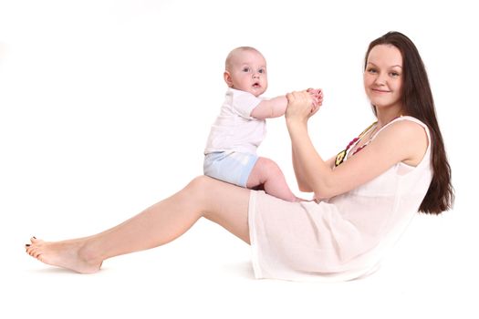 Young mum plays with the small son. A portrait on a white background. The child sits in a lap at mum. A horizontal.