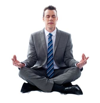 Businessman meditating in lotus position isolated over white background