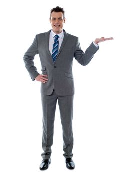 Portrait of a happy young businessman presenting a product against white background - copyspace