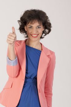 Positive smiling woman with thumbs up and fashionably dressed