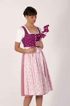 Young woman in traditional costume, with a purple orchid