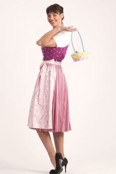 Young woman in Bavarian dress with an Easter basket