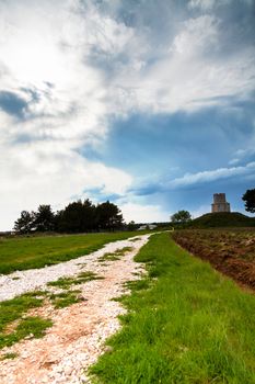 Small church on top of a hill with clouds