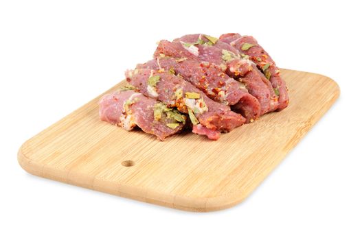 Raw meat, with spices on wooden board. Isolated on white.