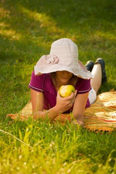 Beautiful woman eating an apple in the park