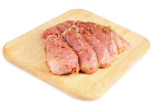 Raw meat, with spices on wooden board. Isolated on white.