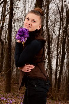 beautiful girl with snowdrops in a forest