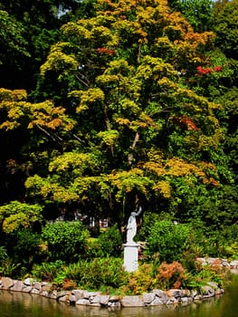 A photograph of a statue at a lake in a public park.