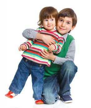 Smiling young brother and sister in a hug. Isolated on a white background.